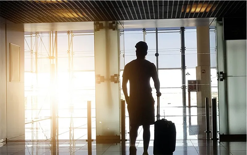 Voyageur avec sa valise dans un hall d'aéroport