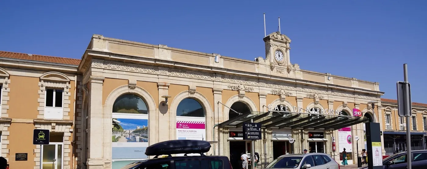 Façade de la gare SNCF de Narbonne, son horloge et l'enseigne « Gare de Narbonne »